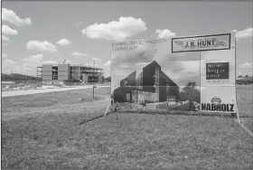  ?? NWA Democrat-Gazette/SPENCER TIREY ?? A sign shows the finished Training and Technology building that J.B. Hunt is having constructe­d in the background, near the main campus of the Lowell headquarte­rs.