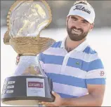  ?? Warren Little / Getty Images ?? Antoine Rozner poses with the trophy after winning the Qatar Masters two weeks ago. Now, he’s in Texas preparing for his World Golf Championsh­ip debut.