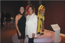  ?? (NWA Democrat-Gazette/Carin Schoppmeye­r) ?? Rachel Pendergraf­t (left) and Gina Pendergraf­t stand by a suit loaned to Crystal Bridges by Gina and Neal Pendergraf­t for “Fashioning America.”