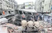  ?? REUTERS ?? Police officers watch rescue operations after a three-storey building collapsed in Bhiwandi, on the outskirts of Mumbai.