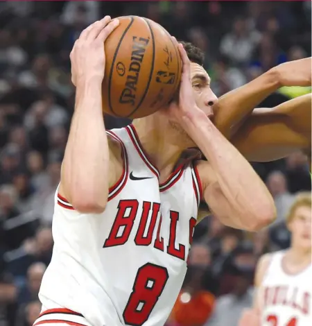  ?? | AP ?? Zach LaVine ( 21 points and seven assists) draws a foul from the Timberwolv­es’ Karl- Anthony Towns during the Bulls’ loss.