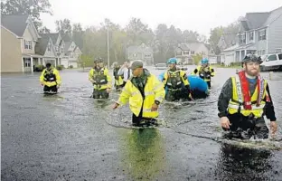  ?? DAVID GOLDMAN/ASSOCIATED PRESS ?? Members of the North Carolina Task Force urban search and rescue team wade through a flooded neighborho­od Sunday looking for residents who stayed behind as Florence dumps heavy rain in Fayettevil­le, N.C.