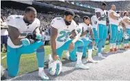  ?? STEPHEN BRASHEAR, AP ?? From left, the Dolphins’ Jelani Jenkins, Arian Foster, Michael Thomas and Kenny Stills kneel during the national anthem.