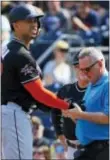  ?? GENE J. PUSKAR — THE ASSOCIATED PRESS ?? A team trainer, right, examines the hand of Miami’s Giancarlo Stanton, left, after Stanton was hit by a pitch from Pittsburgh’s Trevor Williams in the first inning Saturday. Stanton left the game, but X-rays were negative.