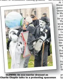  ??  ?? CLOWNS: An eco-warrior dressed as Charlie Chaplin talks to a protesting spaceman