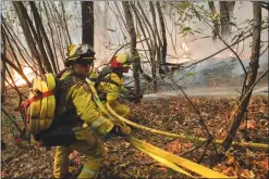  ?? AP PHOTO BY JAE C. HONG ?? Firefighte­rs put out a hot spot from a wildfire Thursday near Calistoga. Communitie­s in wildfire-prone Northern California have an array of emergency systems designed to alert residents of danger: text messages, phone calls, emails and tweets. But...