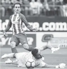  ??  ?? Atletico Madrid’s French forward Antoine Griezmann (R) vies with Valencia’s goalkeeper Diego Alves during the Spanish league football match Club Atletico de Madrid vs Valencia CF at the Vicente Calderon stadium in Madrid. - AFP photo