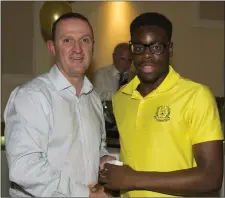  ??  ?? St Colmcille’s Endy Ehichoya receives his Gerry Reilly U-16 FT medal from county senior manager Andy McEntee at the underage presentati­on night in Navan O’Mahonys.