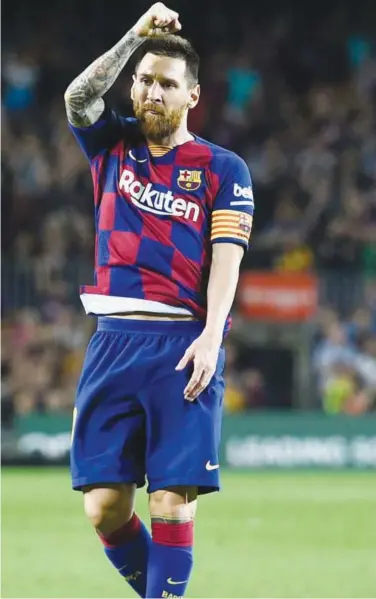  ?? Agence France-presse ?? Barcelona’s Lionel Messi reacts after scoring a goal against Sevilla during their Spanish League at the Camp Nou Stadium on Sunday.