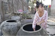  ?? ?? Nguyen Hoai Thuong takes water from a freshwater tank at her home in Vietnam’s southern Ben Tre province.