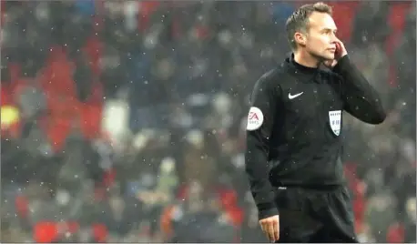  ?? ADRIAN DENNIS/AFP ?? Referee Paul Tierney waits for a VAR decision during the English FA Cup fifth round replay between Tottenham Hotspur and Rochdale at Wembley Stadium in London on Wednesday night.