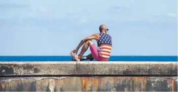  ??  ?? ► Un hombre con una polera de EE.UU., en el malecón habanero, ayer.