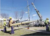  ?? MARK HUMPHREY AP ?? Electrical workers install a new power line pole Friday in Nashville, Tenn.