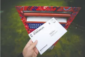  ?? — THE CANADIAN PRESS ?? A provincial election mail-in ballot, sealed in an Elections B.C. return envelope, is about to be deposited in a Canada Post mailbox in Richmond on Saturday.