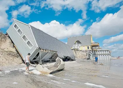  ?? REUTERS ?? Destrucció­n. En Vilano Beach, en Florida, los residentes miran una casa abatida por el huracán Irma.