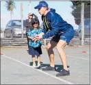  ??  ?? SIMON Eves helps Brooklyn Morunga with her catching technique at Te Puke o Maketu¯.