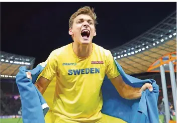  ?? FOTO: KAPPELER/DPA ?? Stabhochsp­ringer Armand Duplantis bejubelt mit der schwedisch­en Fahne seinen 6,05-Meter-Sprung bei der EM in Berlin. Der 18-Jährige machte das Olympiasta­dion zu einem Tollhaus.