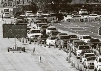  ?? Associated Press file photo ?? Cars line up for COVID-19 testing outside Hard Rock Stadium in Miami Gardens, Fla., in January. New coronaviru­s infections now are averaging 117,000 a day, the lowest since early November.