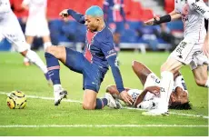  ?? AFP photo ?? Paris Saint-Germain’s French forward Kylian Mbappe gets up as Lorient’s French defender Andreaw Gravillon grimaces on the pitch after falling down during the match at The Parc des Princes Stadium in Paris. -