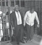  ?? TSVANGIRAY­I MUKWAZHI/AP ?? Zimbabwe’s former finance minister, Ignatius Chombo (left) and Kudzanai Chipanga are led to a prison truck in Harare, Zimbabwe, on Saturday.