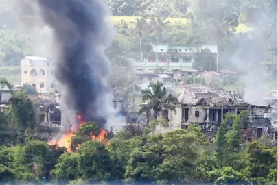  ??  ?? Black smoke billows from burning houses after Philippine Air Force attack planes conducted aerial bombings on militants' positions in Marawi on the southern island of Mindanao on Monday. (AFP)