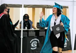  ??  ?? LEFT: Aramea Atencio, 18, receives her diploma from Capital High School Principal Jamie Holladay on Friday.