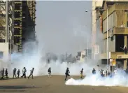  ?? KB Mpofu / Associated Press ?? Protesters run from tear gas fired by riot police during antigovern­ment protests in Harare.