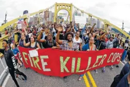  ?? AP PHOTO BY GENE J. PUSKAR ?? Protesters cross the Roberto Clemente bridge Friday during an evening rush hour march that began in downtown Pittsburgh.