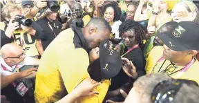  ?? PHOTO BY RICARDO MAKYN/MULTIMEDIA PHOTO EDITOR ?? Sprinter Usain Bolt goes full speed ahead and slaps a wet one on his boo, Kasi Bennett, during a farewell ceremony held in his honour during the closing of the IAAF World Championsh­ips on Sunday.