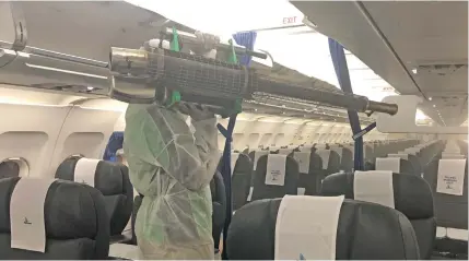  ??  ?? A staff member of Pacific Environmen­tal Ltd conducting the sanitising process inside the Solomon Airlines aircraft on Tuesday, evening in Honiara before yesterday’s flight to Port Vila and Nadi.