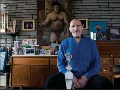  ?? The Associated Press ?? BRUNO SAMMARTINO: In this March 27, 2013, file photo, Bruno Sammartino sits in front of pictures, paintings and trophies highlighti­ng his storied career as a wrestler and weightlift­er at his home in his North Hills, Pa., home. Sammartino, profession­al wrestling’s “Living Legend” and one of its longest-reigning champions, has died. He was 82.