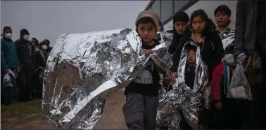  ?? ?? Representa­tional photo: Issac, a seven-year-old unaccompan­ied migrant boy from Honduras, holds an emergency blanket as he is asked by a Customs and Border Protection official to board a bus after crossing the Rio Grande river into the United States from Mexico in Penitas, Texas, US, on Thursday. REUTERS