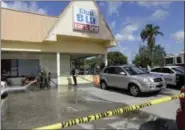  ?? LYNNE SLADKY — THE ASSOCIATED PRESS ?? Fort Myers fire fighters hose down the pavement at the scene of a deadly shooting outside the Club Blu nightclub in Fort Myers, Fla., Monday. Police said the gunfire, which erupted at a swimsuit-themed party for teens, was not an act of terrorism.