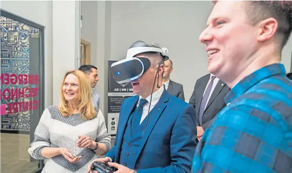  ??  ?? Dr Andrea Szymkowiak and Dr Paul Robertson showcase a VR collaborat­ion with Sony to Finance Secretary Derek Mackay at Abertay.