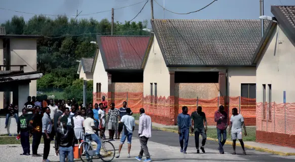  ??  ?? All’interno Sono poco meno di 200 i richiedent­i asilo ospitati nell’ex base dell’aeronautic a militare, a Bagnoli di Sopra, in provincia di Padova