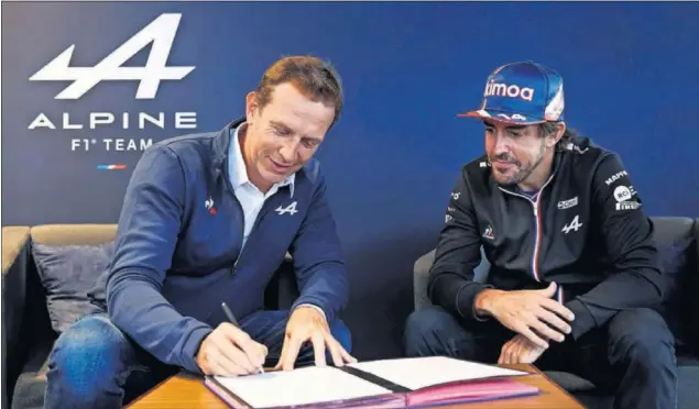  ??  ?? Laurent Rossi, CEO de Alpine, firma el contrato que confirma la segunda temporada de Fernando Alonso con el equipo francés, bajo la atenta mirada del piloto asturiano.