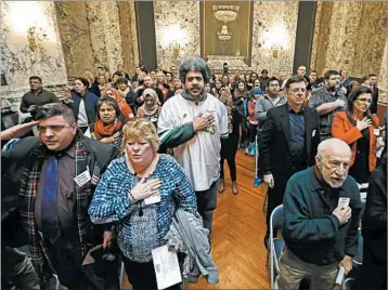  ?? ELAINE THOMPSON/AP ?? Spectators stand for the Pledge of Allegiance during a meeting of Washington state’s Electoral College on Monday.
