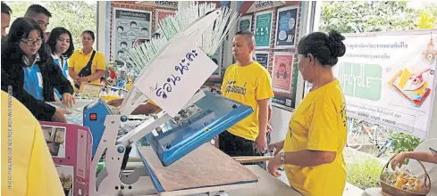  ??  ?? LESSONS IN LAMINATE: Residents of Ban Eua Arthorn Khlong Rangsit Community learn to operate a machine that allows them to turn low-grade, single-use plastic bags into multipurpo­se laminate sheets.