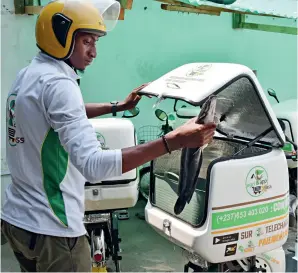  ?? ?? A courier of Agriapp, a mobile e-commerce platform for agricultur­al products, prepares a live fish delivery in Douala, Cameroon, on December 4, 2019