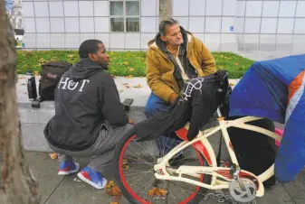  ??  ?? Outreach worker Cedric Bowser (left) talks with homeless man Ron Quasebarth as he tries to set Quasebarth up to enter a Navigation Center and receive services in San Francisco.