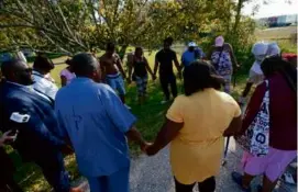  ?? JOHN RAOUX/ASSOCIATED PRESS ?? Residents near the shooting site, which is in a predominan­tly Black neighborho­od in Jacksonvil­le, Fla., gathered to pray.