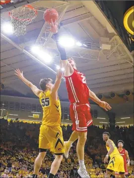  ?? Charlie Neibergall Associated Press ?? WISCONSIN’S Ethan Happ shoots over Iowa forward Luka Garza during the first half. Happ finished with 13 points, seven rebounds and five assists.