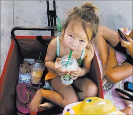  ?? Elizabeth Brumley ?? Las Vegas Review-journal Miley Yeh, 5, sips a cold beverage Wednesday while sitting first in line at Wet ‘n’
Wild Las Vegas water park.