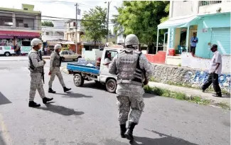  ?? EDWARD ROUSTAND ?? Grupo de militares durante labor de vigilancia en el barrio Guachupita.