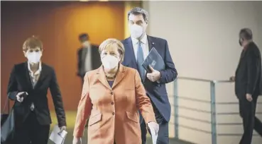  ??  ?? 0 Chancellor Angela Merkel and Bavarian Governor Markus Soeder arrive to speak to the media.