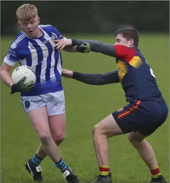  ??  ?? Cian Byrne, the Good Counsel play-maker, is challenged by St. Fintan’s defender Reuben Cantwell.