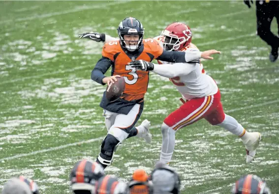  ?? Helen H. Richardson, The Denver Post ?? With 18 seconds left on the clock in the second quarter, Broncos quarterbac­k Drew Lock tries to pass the ball before getting taken down by Kansas City defensive end Tanoh Kpassagnon at Empower Field at Mile High on Sunday.