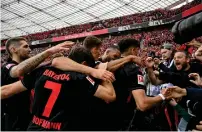  ?? — AFP ?? Bayer Leverkusen players celebrate their third goal with fans.
