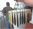  ?? MARK HOFFMAN / MILWAUKEE JOURNAL SENTINEL ?? Casey Schalkowsk­i holds some of the lures he can choose from while fishing from his raft.
