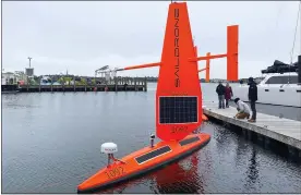  ?? SUSAN RYAN — SAILDRONE VIA AP ?? A Saildrone Explorer un-crewed surface vehicle, or ocean drone, is prepared for launch at a dock, in Newport, R.I. Three of the drones were to be launched Thursday and are expected to travel along the Gulf Stream, collecting data in tough winter conditions that would be challengin­g for traditiona­l ships with crews.